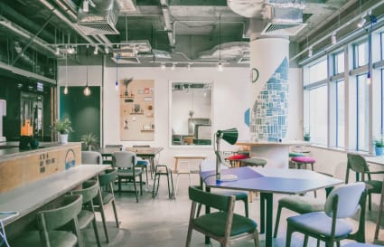Stylish coworking space with modern décor, natural light, and versatile seating options.
