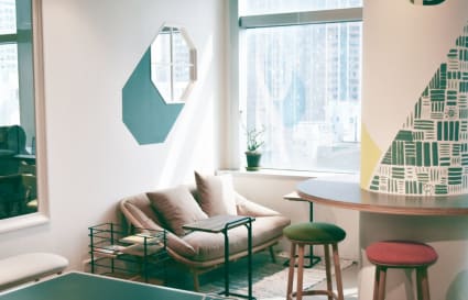 Bright, modern coworking space with cozy seating and vibrant decor. Ideal for collaboration.