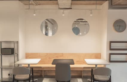 Modern coworking area with sleek tables, cozy seating, and stylish wall accents.