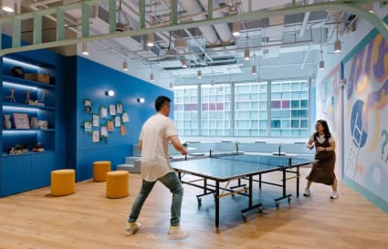 Vibrant coworking space with playful vibe, featuring a ping pong table and modern decor. Ideal for collaboration.
