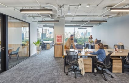 Modern coworking space with city views, collaborative desks, and natural light in Bang Rak.