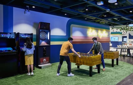 Dynamic coworking space with arcade games, foosball, and a vibrant, social atmosphere.