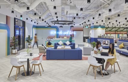 Bright, modern coworking space with stylish seating, vibrant decor, and ample natural light.