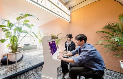 Vibrant coworking space with relaxation area, lush greenery, and arcade games for creative breaks.