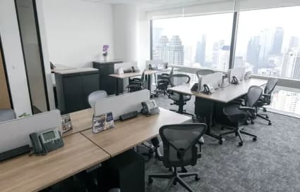 Bright coworking space with city views, ergonomic chairs, and collaborative desks.