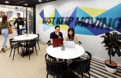 Vibrant coworking area with modern décor, collaborative seating, and motivational wall art.
