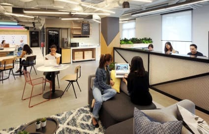 Vibrant coworking space with modern furniture, ample natural light, and collaborative work areas.