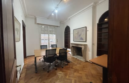 Elegant coworking room with natural light, a large table, and cozy fireplace in Montevideo.