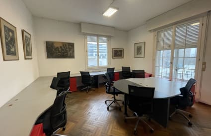 Bright coworking space with modern seating, natural light, and flexible workstations.