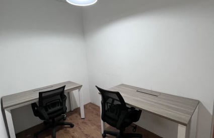 Efficient workspace with two desks and ergonomic chairs, ideal for focused productivity.