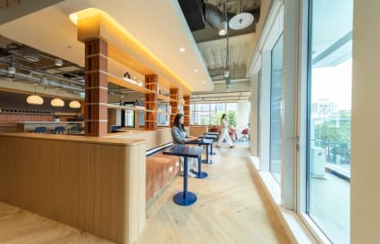Bright, modern coworking space in Taipei featuring open seating and expansive windows.
