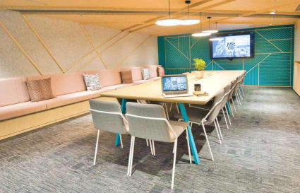 Modern coworking space with stylish seating, conference table, and vibrant decor. Ideal for collaboration.