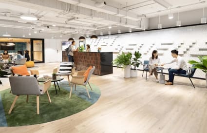 Modern coworking space in Taipei featuring stylish seating, vibrant lighting, and natural accents.