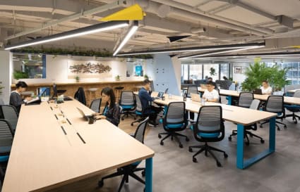Spacious coworking area in Taipei with modern desks, ergonomic chairs, and ample natural light.