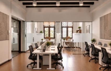 Modern coworking space with natural light, sleek desks, and private meeting rooms.