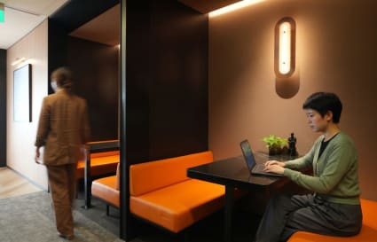 Stylish coworking booths with modern lighting and comfortable seating in The Gateway, Singapore.