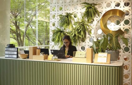 Welcoming reception area adorned with greenery in a thriving coworking space.