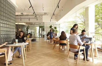 Bright coworking space with natural light, modern furniture, and vibrant networking atmosphere.