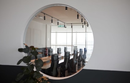 Modern coworking space with sleek boardroom, ample seating, and natural light.
