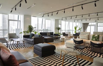 Spacious coworking area with modern seating, ample natural light, and vibrant city views.