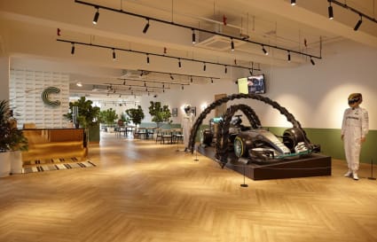 Dynamic coworking space with modern decor and natural light. Features unique Formula 1 car display.