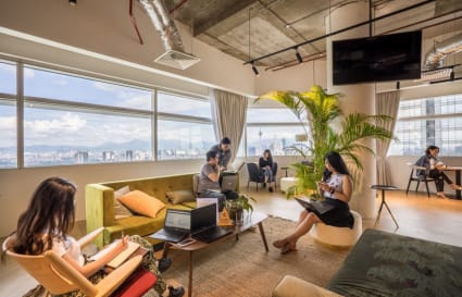 Bright coworking space with city views, modern seating, and relaxed atmosphere in Kuala Lumpur.