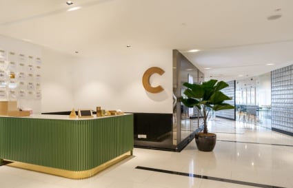 Modern coworking space with sleek decor, spacious layout, and lush plant accents.