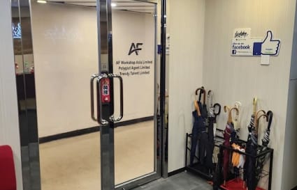 Welcoming entrance with sleek glass doors and convenient umbrella storage. Ideal for coworking.