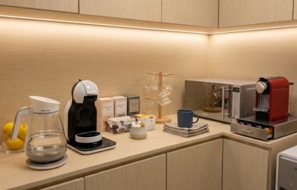 Modern coworking kitchenette with coffee machines and ample counter space in Hok Yuen.