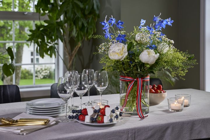 et vakkert bord pyntet til 17. mai, med en frodig bukett med peoner fra interflora