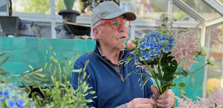 Finn Schjøll studerer nøye en bukett med sommerens blomster