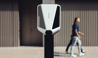 Easee Charge Max i et sterilt miljø med mennekser som går bak. 