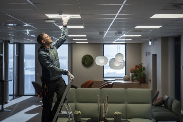 En mannlig elektriker som monterer Glamox Wireless i taket