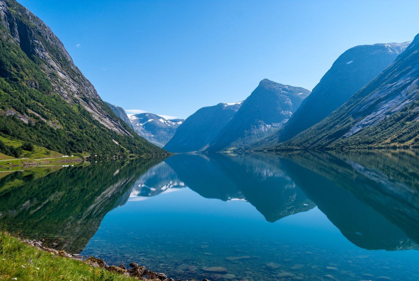 Panaramabilda av Sogndalsfjorden med fjeld og stille vann. 