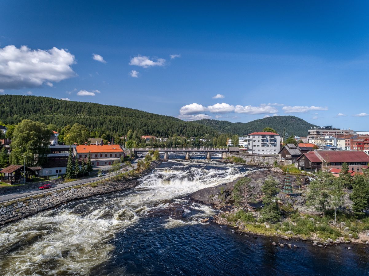 Flyfoto av Kongsberg med elevn og flere bygninger