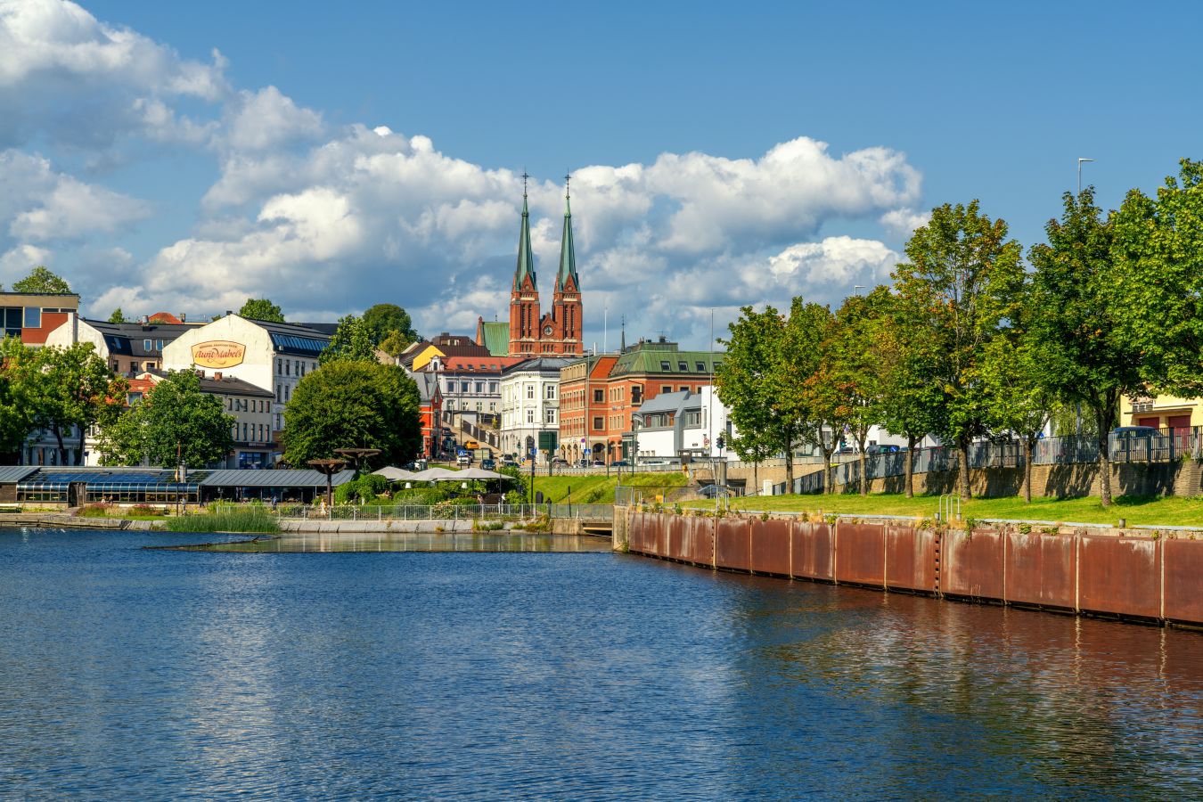 Bilde av Skien ved vannet med en kirke i bakgrunnen. 