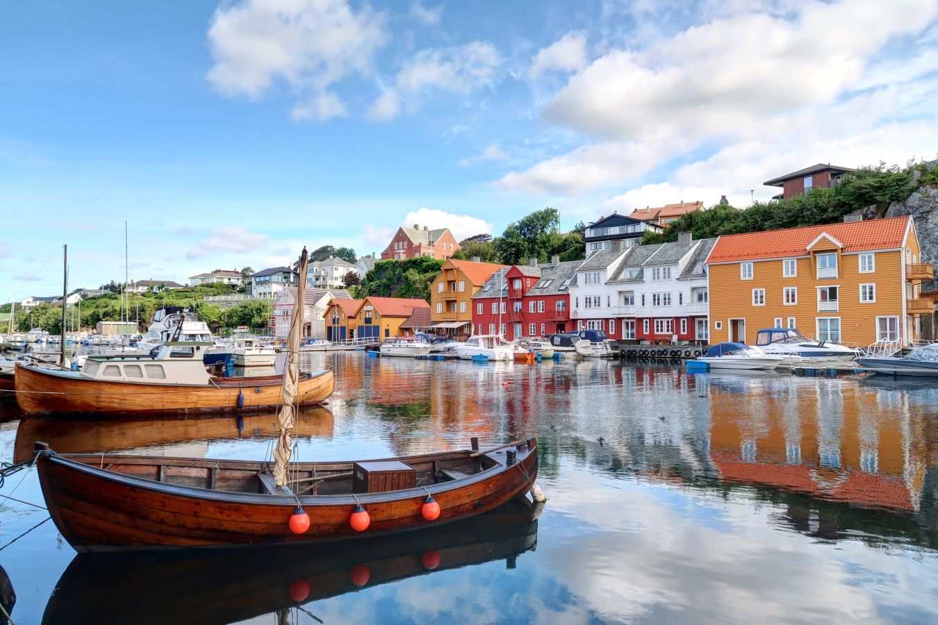 Bilde av Haugesund med båter på vannet og fargerike bygninger i bakgrunnen. 