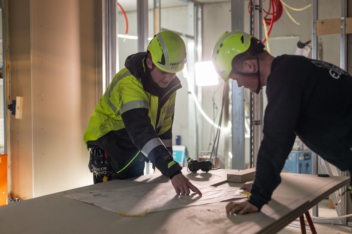 To ansatte som peker på en plantegning