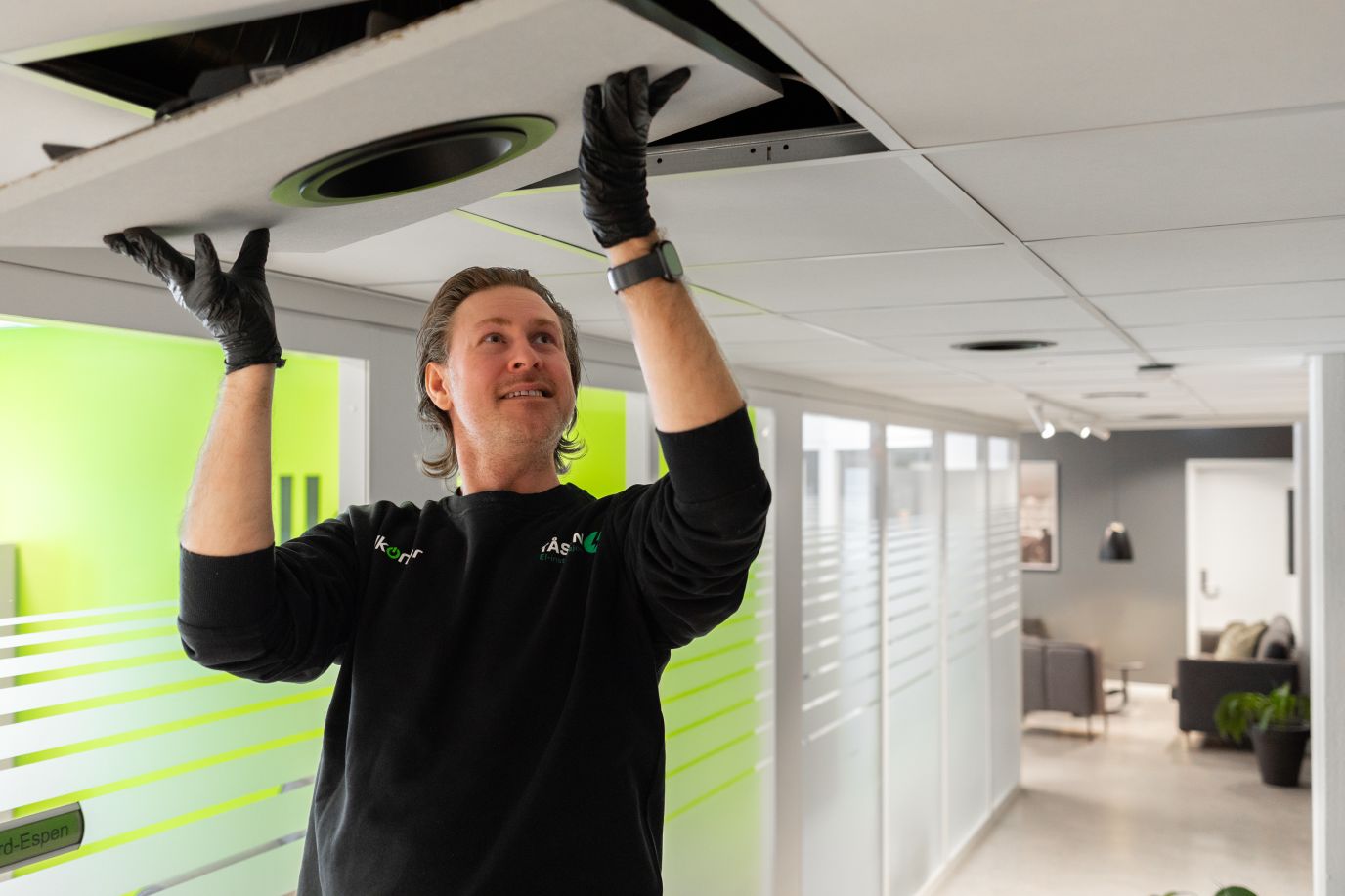 mannlig elektriker monterer takbelysning på kontor