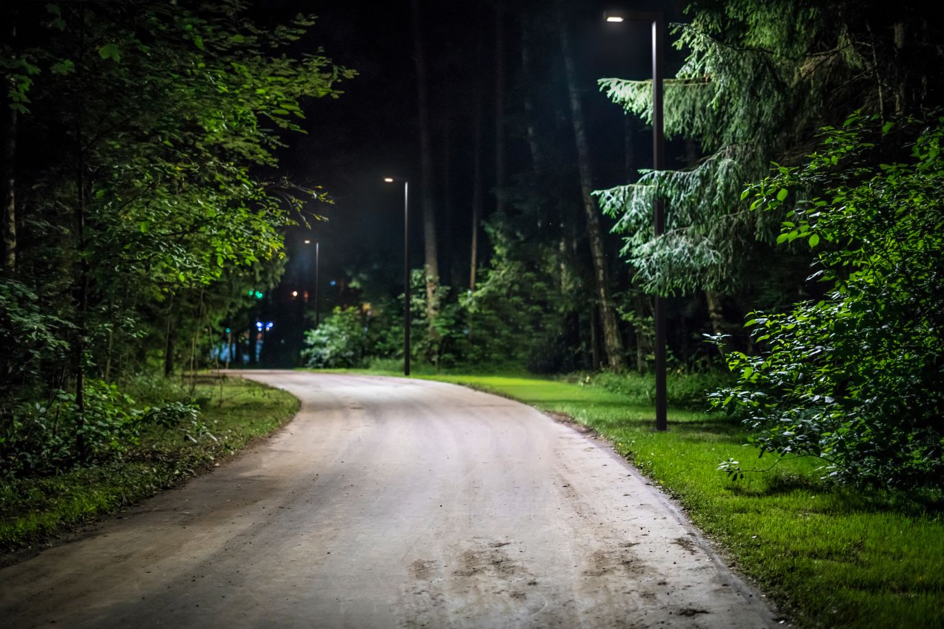 En park opplyst med lyktestolper, på kveldstid