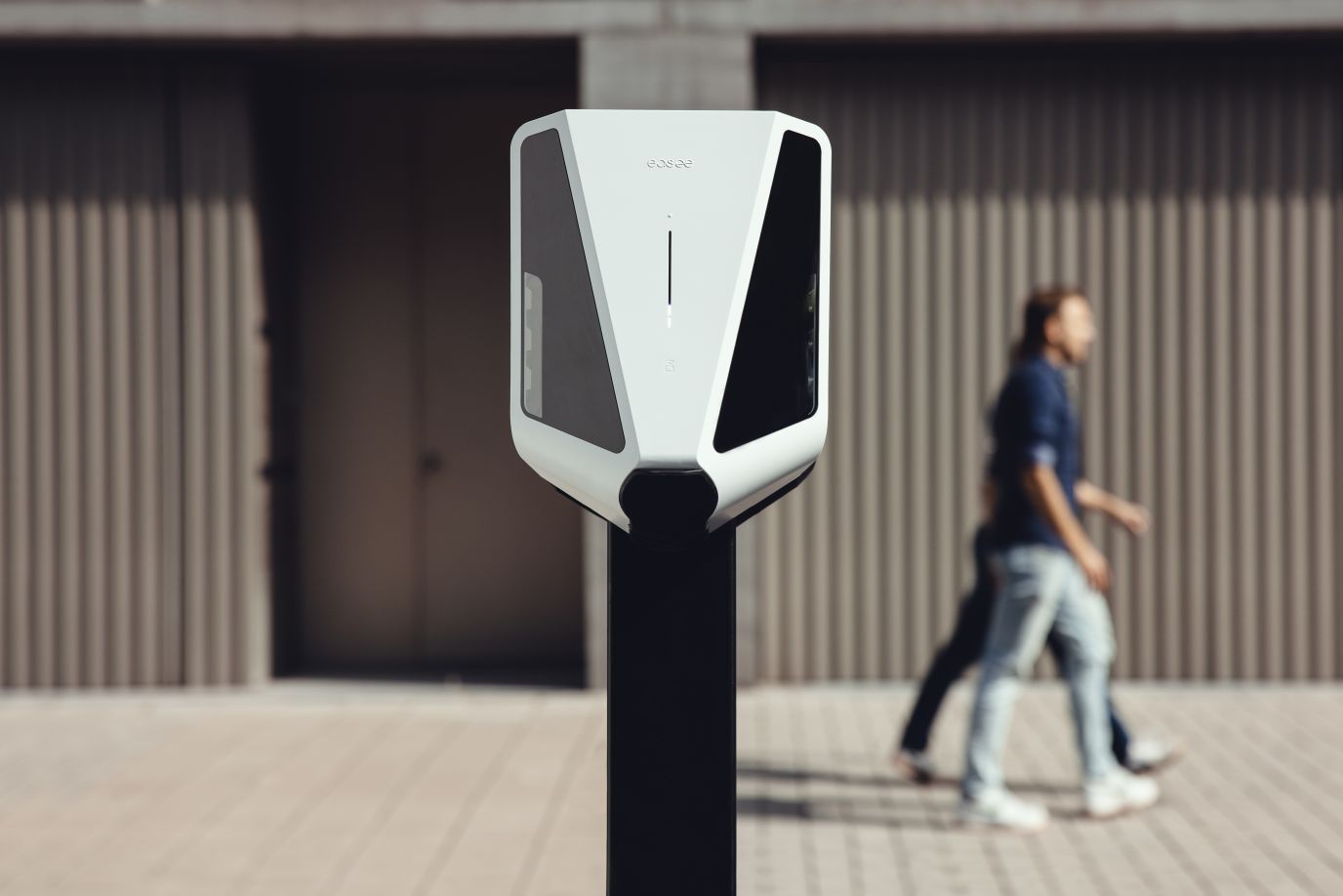 Easee Charge Max i et sterilt miljø med mennekser som går bak.