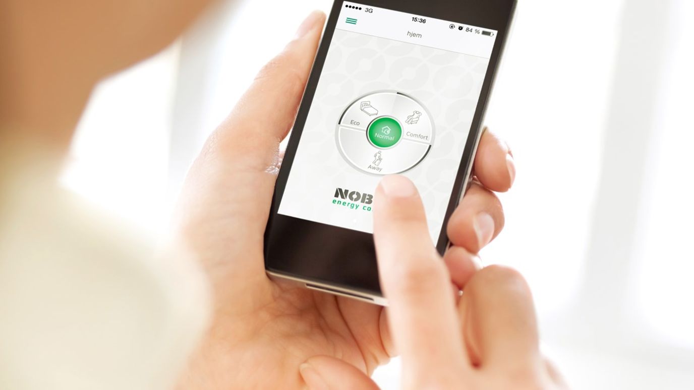 En person som bruker en varmestyringsapp fra Nobø på mobilen