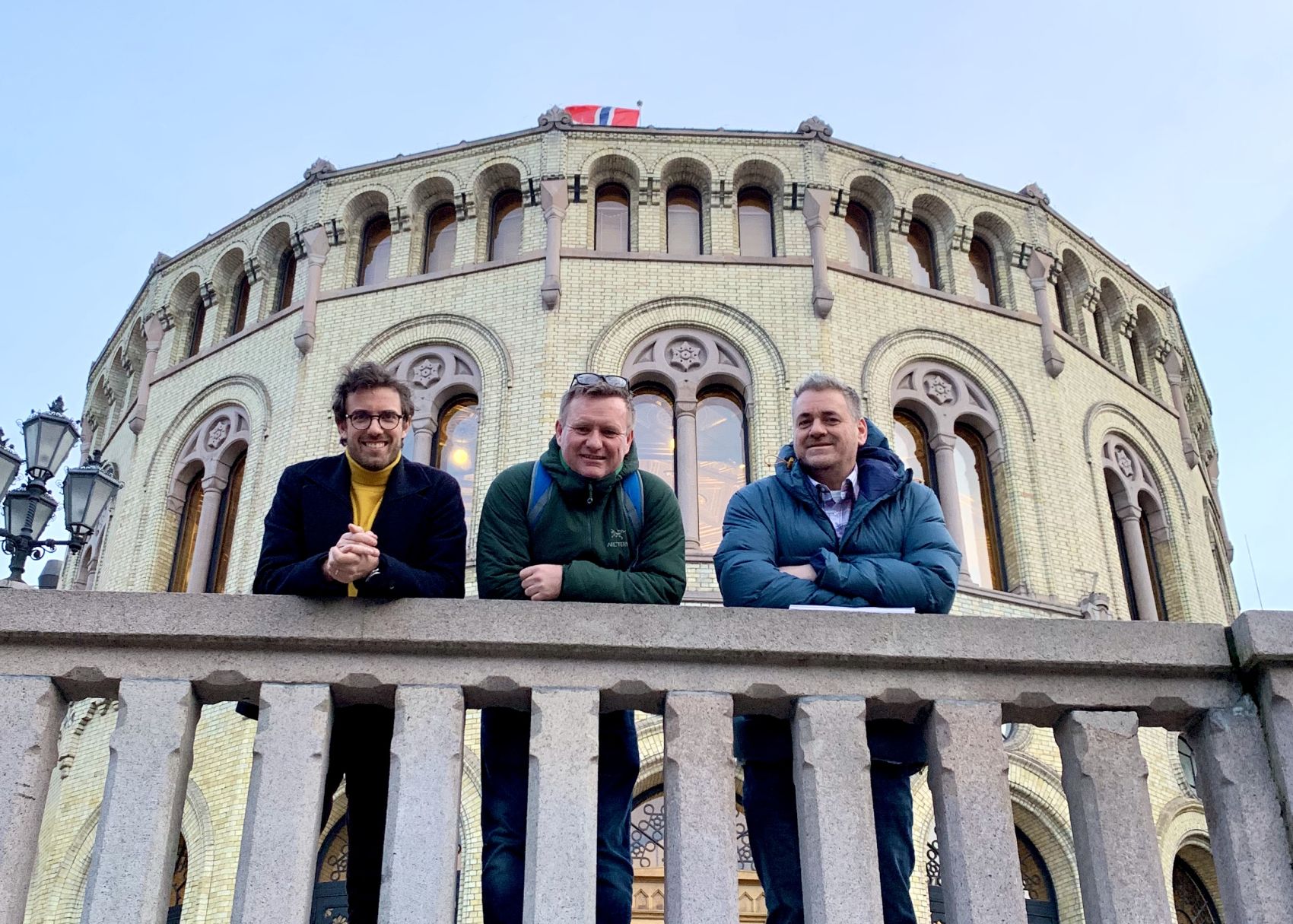 Tre menn fra Stendi poserer foran Stortinget