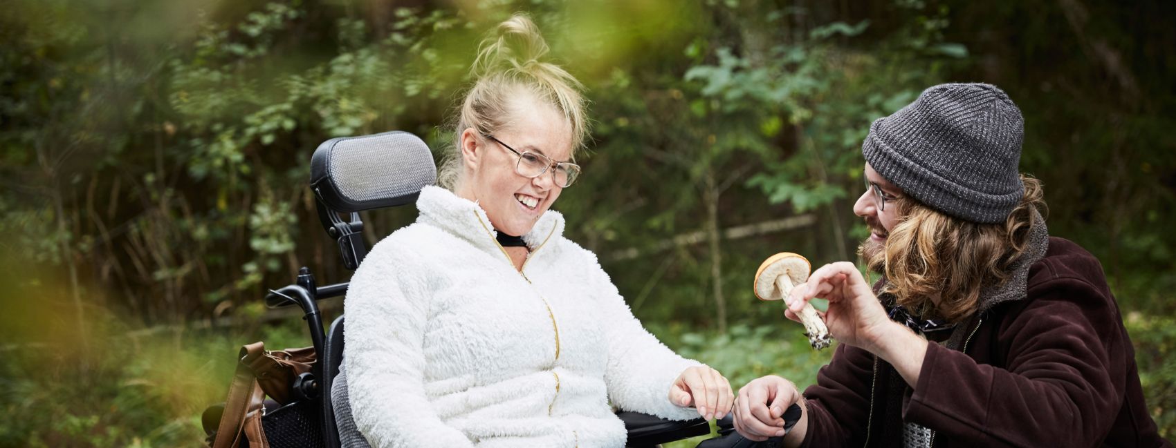 Stendi assistent som bistår ung kvinne med funksjonsnedsettelse