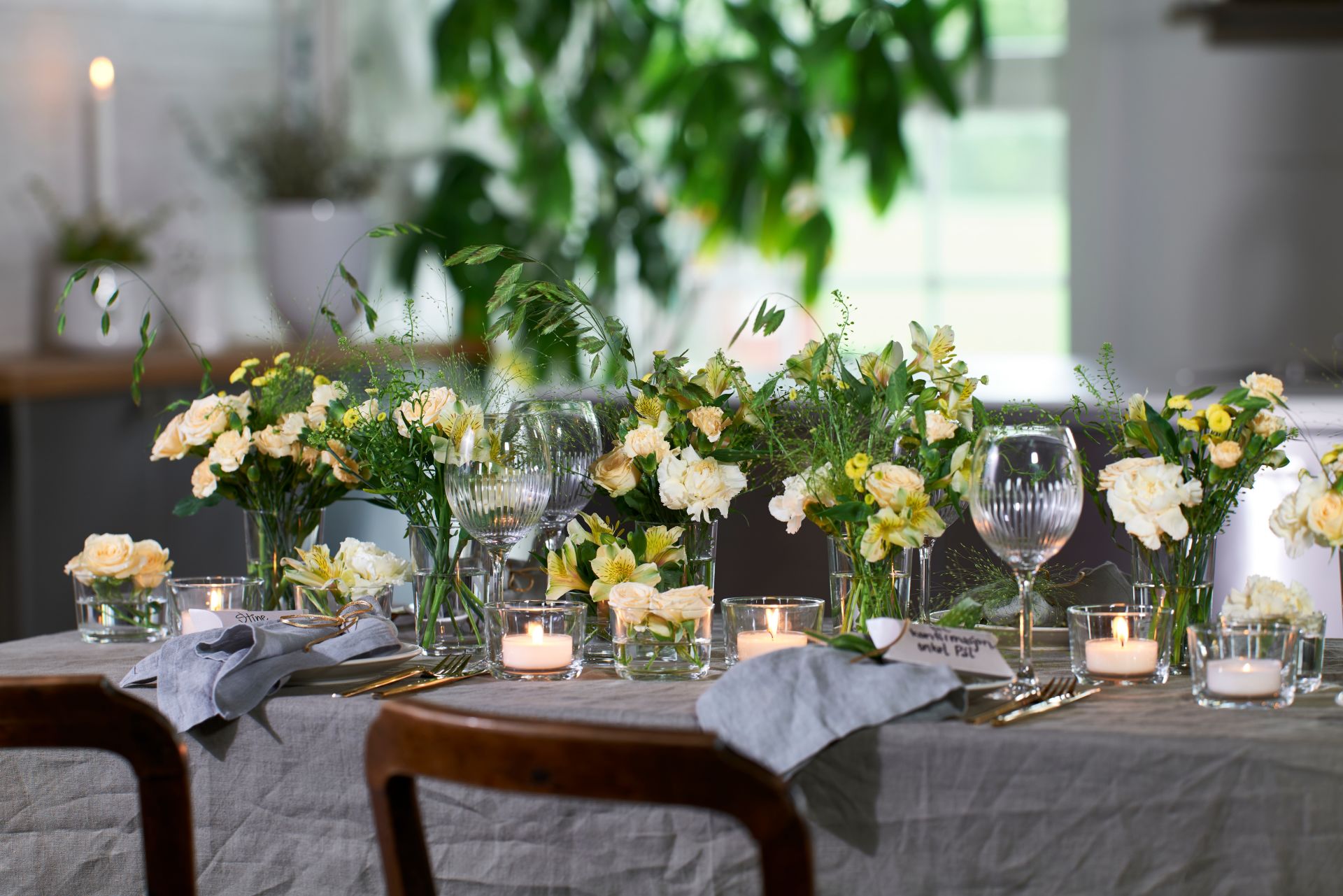 bord dekket med servise, blomsterdekorasjoner og telys