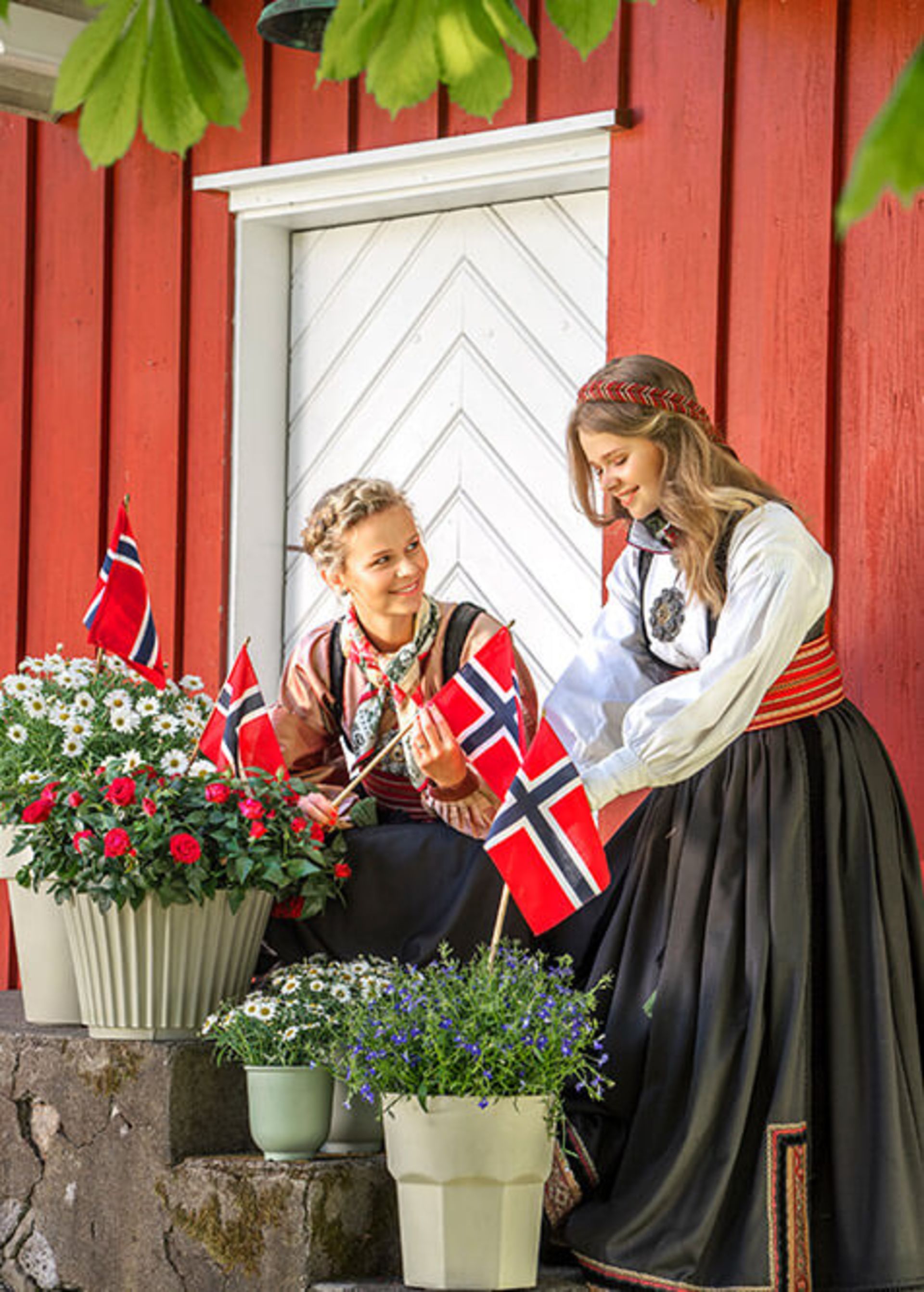 To kvinner pynter ute til 17. mai
