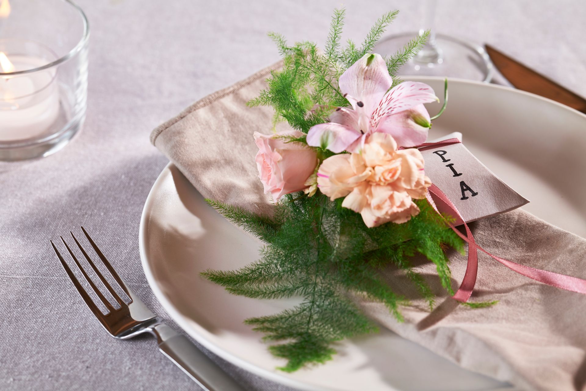 bord dekket med servise, og navnelapper festet med blomster