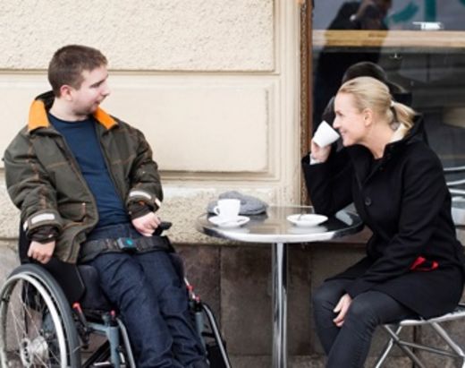 Ung man i rullestol ut på café med sin personlig assistent fra Stendi. 