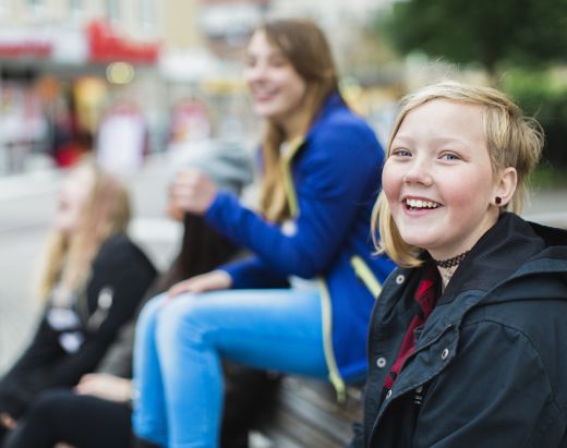 En tenåringsjente som bor i fosterhjem smiler bredt.