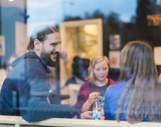 En fosterfar via Stendi Barnevern sitter på kafe sammen med to tenåringsjenter.